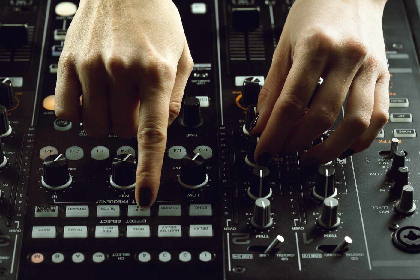 Nahaufnahme der Hände eines DJs am Mischpult