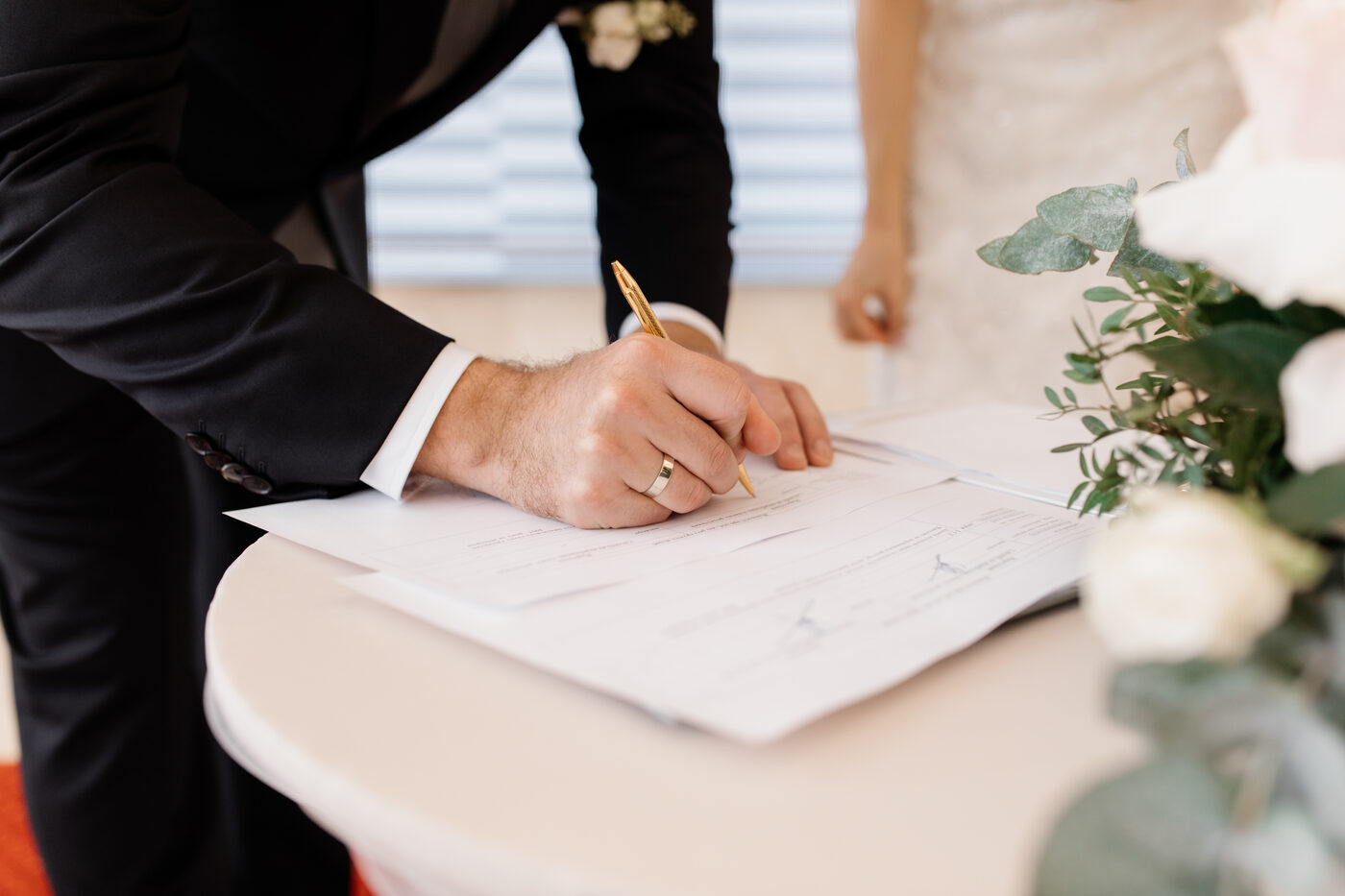 Verliebtes Paar unterschreibt die Heiratsurkunde im Standesamt